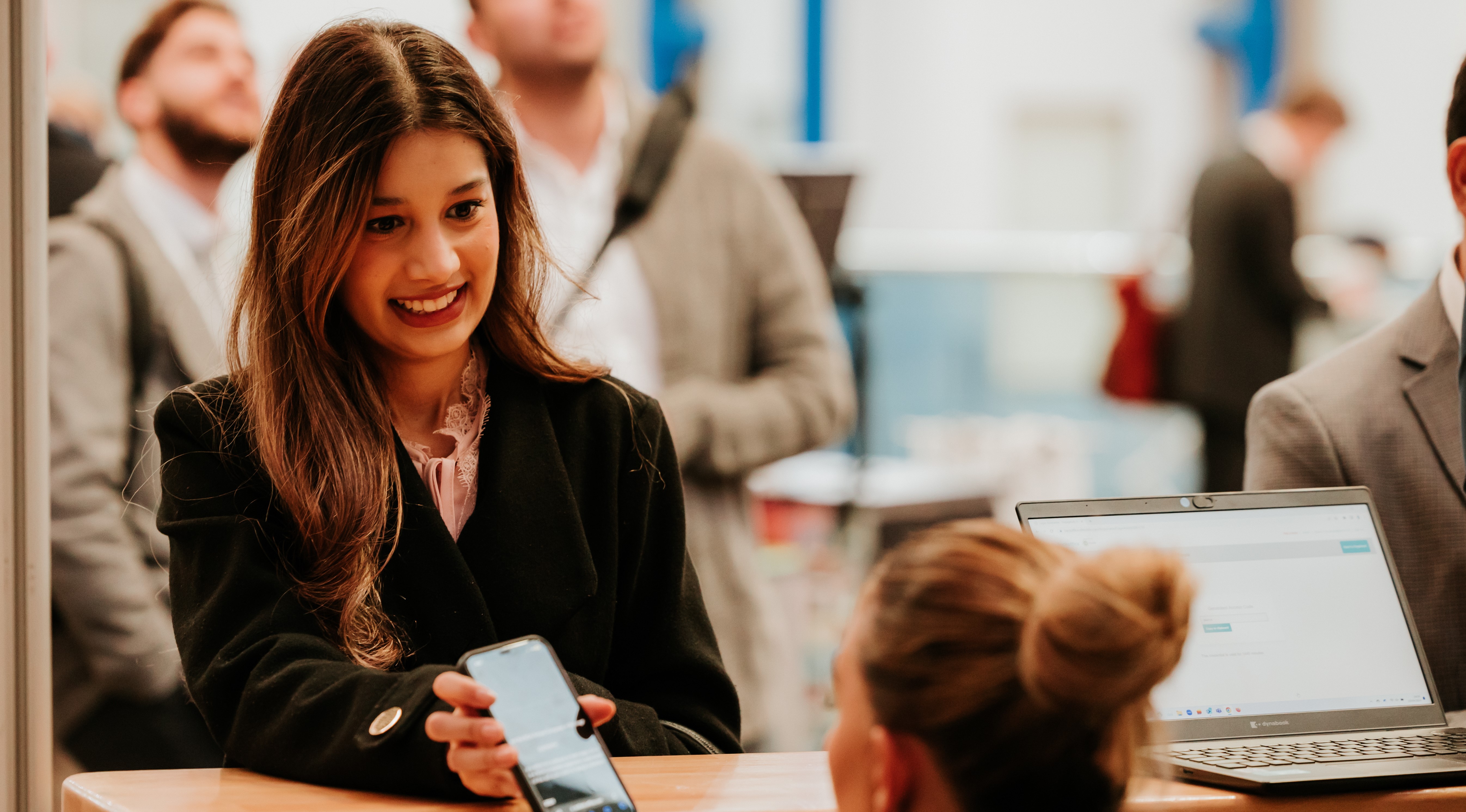 Lady showing phone at registration 2024.jpg